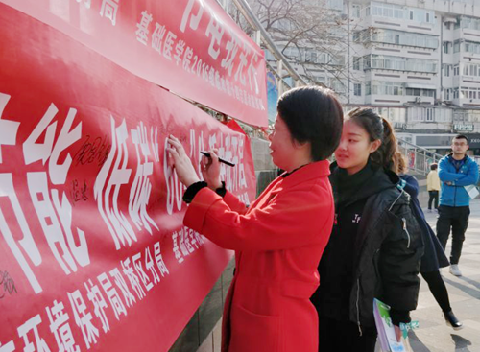 志愿者引导市民进行横幅签名活动